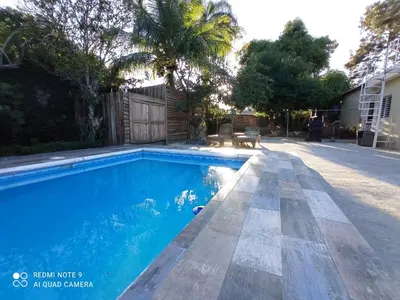 a swimming pool with blue water in a yard at Paraíso Hortensia Honeymoon Suite in Santiago de los Caballeros