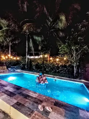 a couple in a swimming pool at night at Paraíso Hortensia Honeymoon Suite in Santiago de los Caballeros