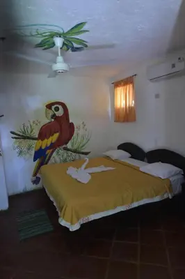 a bedroom with a parrot painted on the wall at Hotel El Rancho Sosua in Sosúa