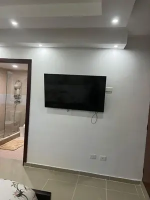 a flat screen tv on a white wall at Residencial Pancho III in Los Mameyes