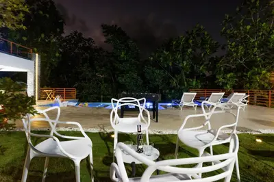 a group of white chairs sitting in the grass at VILLA LEMON Samaná in El Limón
