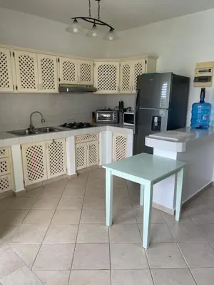 a kitchen with a table and a refrigerator at Waterfront apartment in Las Terrenas