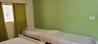two beds in a room with green walls at Room 4 in Río San Juan