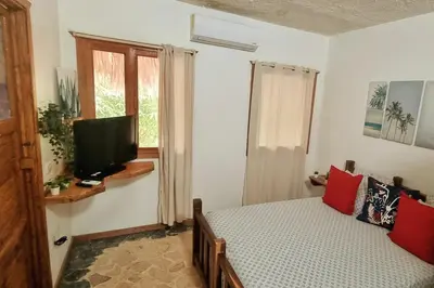 a bedroom with a bed with a television and a window at Coco's Apartment near La Playita beach in Las Galeras