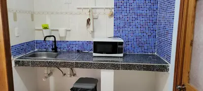 a bathroom with a sink and a microwave on a counter at Room 3 in Río San Juan