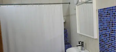 a bathroom with a white shower curtain and a toilet at Room 3 in Río San Juan