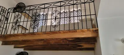 a staircase with a wrought iron railing and wooden stairs at Room 7 in Río San Juan