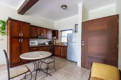a kitchen with a table and a refrigerator at Garden Studio, Ocean Dream in Cabarete