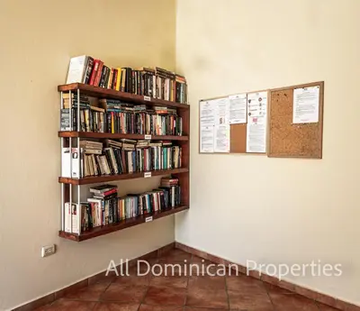 a book shelf filled with books on a wall at Garden Studio, Ocean Dream in Cabarete