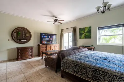 a bedroom with a bed and a mirror and a tv at Garden Studio, Ocean Dream in Cabarete