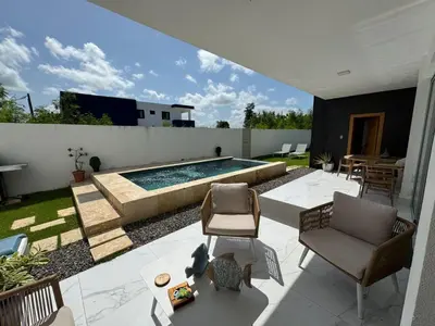 a patio with a pool and chairs and a table at Villa Noah in Bayahibe