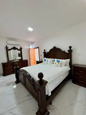 a bedroom with a large wooden bed with a mirror at Villa Noah in Bayahibe