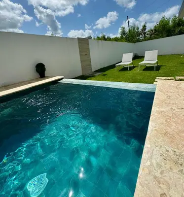 a swimming pool with two chairs in a yard at Villa Noah in Bayahibe