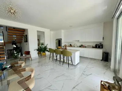 a kitchen with white cabinets and a table and chairs at Villa Noah in Bayahibe