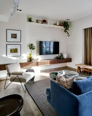 a living room with a blue couch and a tv at Regatta Living Suites by Yellowkey in Santo Domingo
