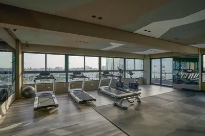 a gym with treadmills and exercise equipment in a building at Regatta Living Suites by Yellowkey in Santo Domingo