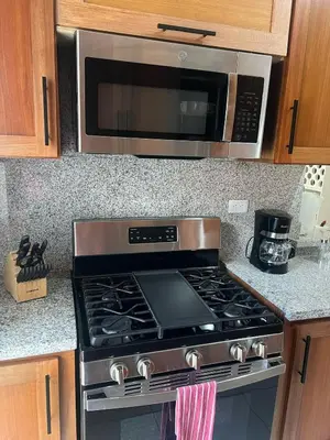 a kitchen with a stove and a microwave at Escapada perfecta, apartamento frente al mar in San Felipe de Puerto Plata