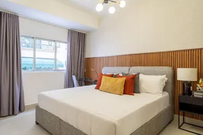 a bedroom with a large white bed with colorful pillows at Splendid-KingBed-3BR-Pool-AC-Modern-WiFi-Yellowkey in Santo Domingo