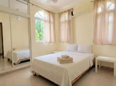 a bedroom with a bed and a large mirror at 2-Bedroom Beach Apartment with Pool Costambar in San Felipe de Puerto Plata
