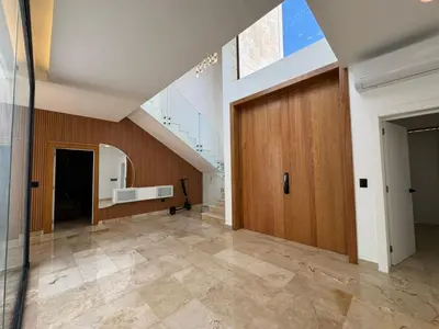 a hallway with a large wooden door in a building at Golf 218 Playa Nueva Romana in San Pedro de Macorís
