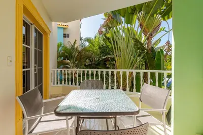 a patio with a table and chairs on a balcony at Spacious 2 Bedroom Condo with Pool close to Beach in Punta Cana