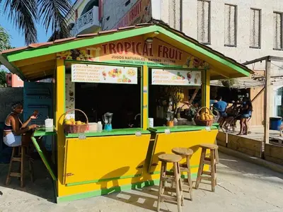 a yellow and green food cart with stools at Spacious 2 Bedroom Condo with Pool close to Beach in Punta Cana
