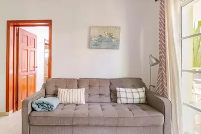 a living room with a brown couch in a room at Spacious 2 Bedroom Condo with Pool close to Beach in Punta Cana
