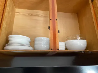 a wooden cabinet with plates and bowls in it at Spacious 2 Bedroom Condo with Pool close to Beach in Punta Cana