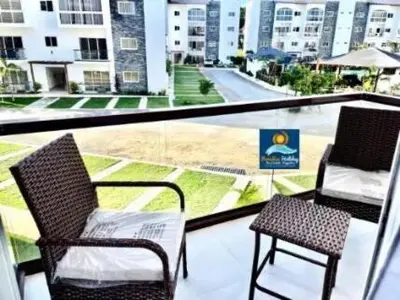 a balcony with two chairs and a view of a street at Armonía apartment in Las Terrenas