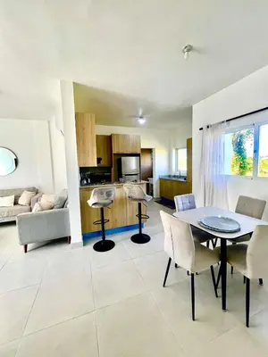 a kitchen and living room with a table and chairs at Armonía apartment in Las Terrenas