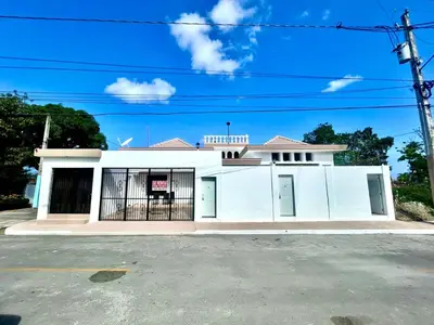 a white building with a gate in front of it at Room 1 in Río San Juan