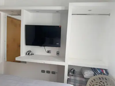 a bedroom with a flat screen tv on a wall at Lujoso townhouse en Boca Chica in Boca Chica