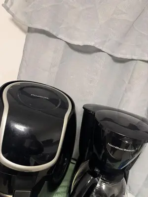 a black coffee maker sitting next to a cup at Lujoso townhouse en Boca Chica in Boca Chica