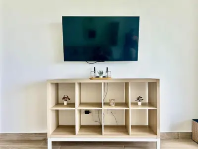 a tv on a white wall with a shelf at Peaceful 2BR 2BA in Bonita with Pool and Palm Tree Views in Las Terrenas