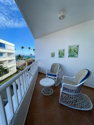 two chairs and a table on a balcony with the ocean at Sea front apartment, Juan Dolio, San Pedro in San Pedro de Macorís