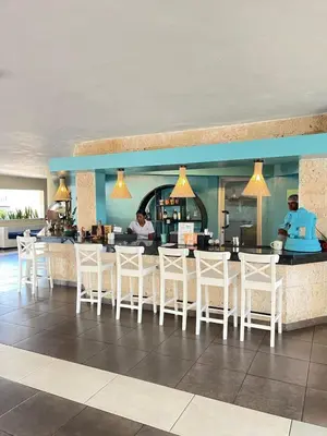 a restaurant with white chairs and a bar at Sea front apartment, Juan Dolio, San Pedro in San Pedro de Macorís