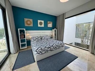 a bedroom with a bed and a blue wall at Golf 218 Nueva Romana Beach in San Pedro de Macorís