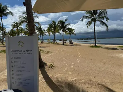 a sign in front of a beach with palm trees at Golf 218 Nueva Romana Beach in San Pedro de Macorís