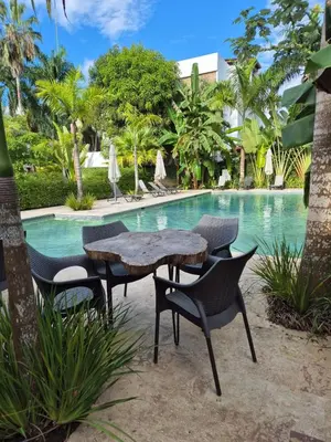 a table and chairs next to a swimming pool at Punta Popy 3BR Duplex with Pool, Walk to Beach in Las Terrenas
