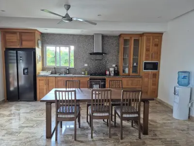 a kitchen with a table and chairs and a black refrigerator at Punta Popy 3BR Duplex with Pool, Walk to Beach in Las Terrenas