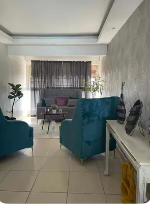 a living room with a blue couch and a table at Acogedor apartamento en la Jacobo majcluta in Jacagua