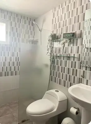 a white bathroom with a toilet and a sink at Acogedor apartamento en la Jacobo majcluta in Jacagua