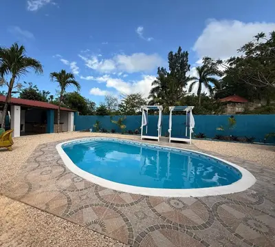 a swimming pool with two chairs in a yard at Villa Las Tortugas # 2 in Sousa in Sosúa