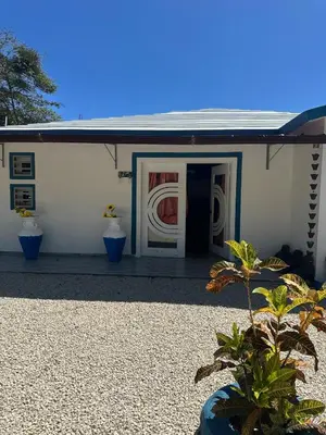 a white building with a door with a painting on it at Villa Las Tortugas # 2 in Sousa in Sosúa