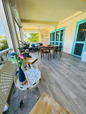 a porch with a table with flowers on it at Romantic Beachfront Retreat In Las Terrenas - Everything You Could Want - 2 Rooms in Las Terrenas