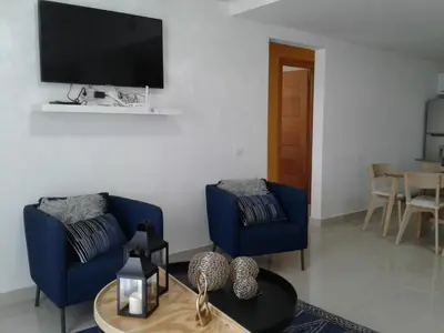 a living room with two blue chairs and a tv at Apartamento en Boca Chica T1 610 in Boca Chica