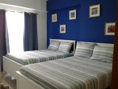 two beds in a bedroom with blue walls at Apartamento en Boca Chica T1 610 in Boca Chica