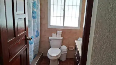 a small bathroom with a toilet and a window at CortLang Vacation Rentals, Costambar in San Felipe de Puerto Plata