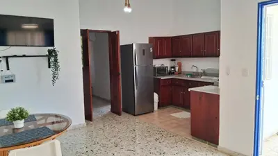 a kitchen with a stainless steel refrigerator and a table at CortLang Vacation Rentals, Costambar in San Felipe de Puerto Plata