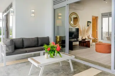 a living room with a couch and a table with flowers at Villa Mustique - Perfect tropical paradise in El Limón